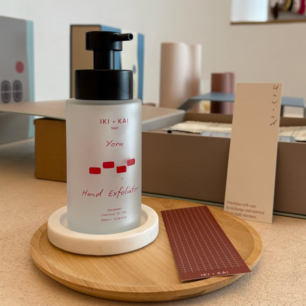 IKI+KAI Yoru Hand Exfoliator on a wooden tray with a blurred indoor background